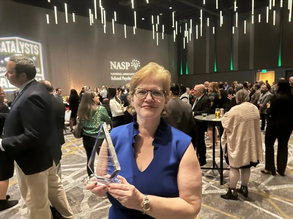 Dr. Andria Amador, Senior Director of Behavioral Health Services, holding the NASP Presidential Award at the 2025 convention